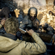 A mean beardy zombie attacks our boy in Resident Evil Village.